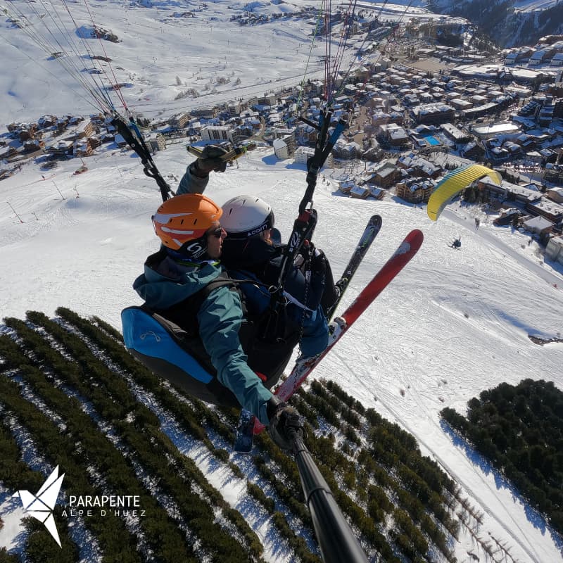 Parapente biplace en vol découverte au-dessus des pistes de l’Alpe d’Huez, après un décollage depuis le Signal.