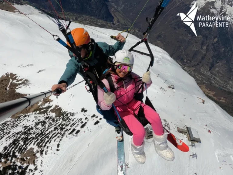 Parapente biplace au-dessus de l'Alpe d'Huez, vue panoramique sur la station et le massif des Écrins